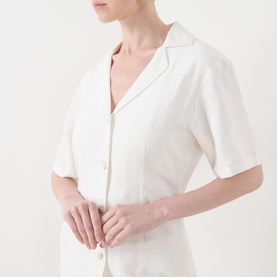 Model wearing Fabienne Chapot Melody Mini Shirt Dress in Cosy White, showing notch lapel collar, short sleeves and front button fastening.