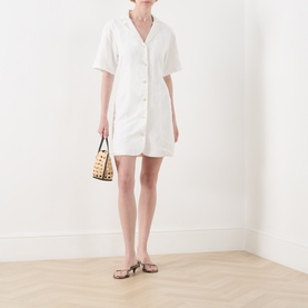 Model wearing Fabienne Chapot Melody Mini Shirt Dress in Cosy White with notch lapel, short sleeves and button front, styled with woven bag and