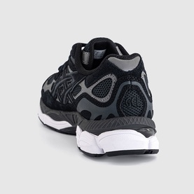 Asics trainer in graphite grey and black, rear three-quarter view showing cushioned sole, mesh upper, and branded heel detail with white outsole.