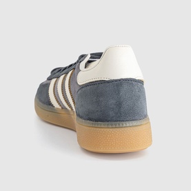 Adidas grey suede low-top trainer with off-white three stripes, cream heel tab and gum rubber sole, rear three-quarter view
