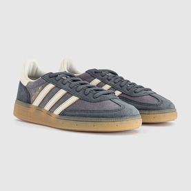 Adidas grey suede low-top trainers with off-white three-stripe detailing, cream midsole, and gum rubber outsole