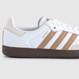Adidas Samba trainer in white and cardboard tan with gold branding, three stripes, and dark gum sole.