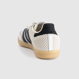 Adidas trainer in off-white with carbon black three-stripe detail, textured knit upper, and gum sole, heel view