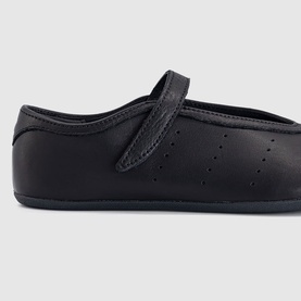 Adidas black leather mary-jane flat shoe with velcro strap, perforated toe detail, and dark sole.