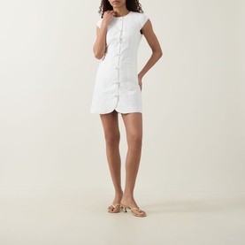 Model wearing Aligne Jennie Shirt Dress in white, mini length with cap sleeves and knot front fastenings, styled with tan sandals
