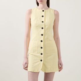 Model wearing Aligne Leah Mini Dress in Lemon, sleeveless with button front fastening and patch pockets