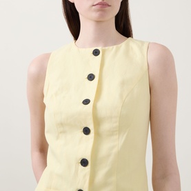 Model wearing Aligne Leah Mini Dress in lemon, sleeveless with round neckline and dark front buttons, lightweight linen-blend fabric