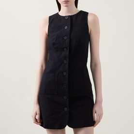 Model wearing Aligne Leah Mini Dress in black, sleeveless linen-blend style with front button fastening, patch pockets and round neckline.