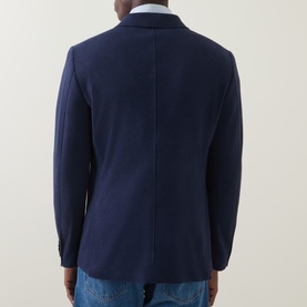 Model wearing Gant Patch Pocket Single-Breasted Blazer in Evening Blue, rear view showing back seam and rear vents, styled with jeans.