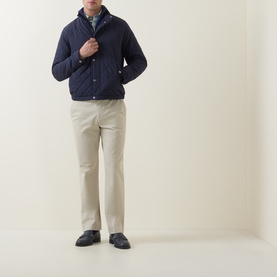 Model wearing Gant Evening Blue quilted cotton casual jacket, styled with beige chinos and dark loafers