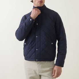 Model wearing Gant Evening Blue quilted casual jacket with press-stud fastening, styled with stone chinos.