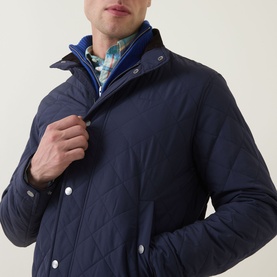 Model wearing Gant Evening Blue quilted casual jacket, styled over blue gilet and check shirt, snap button fastening visible.