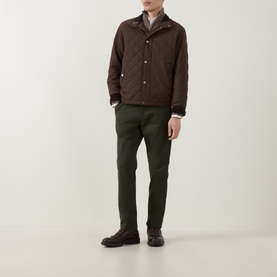 Model wearing Gant Classic Quilted Jacket in black brown with funnel neck, styled with olive trousers and brown boots.