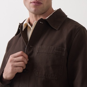 Model wearing Gant Black Brown cotton casual jacket, zipped at collar, with cream polo shirt underneath