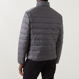Model wearing Gant Dusky Anthracite quilted casual jacket, rear view, styled with black trousers.