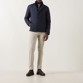 Model wearing Gant Evening Blue quilted casual jacket with stand collar, styled with cream trousers and dark loafers.