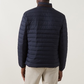 Model wearing Gant Evening Blue quilted casual jacket, shown from rear, with beige trousers. Ribbed collar detail visible.