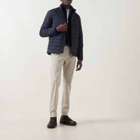 Model wearing Gant Evening Blue quilted casual jacket with stand collar, styled with cream chinos and brown leather loafers.