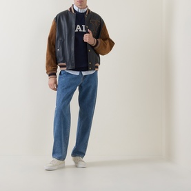 Model wearing Gant Varsity Logo Leather Bomber Jacket in navy with tan sleeves, styled with navy logo sweatshirt, blue jeans and white trainers