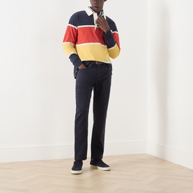 Model wearing Gant Evening Blue Casual Trousers, styled with a navy, red and yellow stripe rugby shirt and navy trainers.