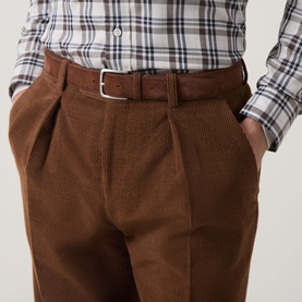 Model wearing Gant Mahogany Brown casual trousers in corduroy, styled with a brown leather belt and plaid shirt.