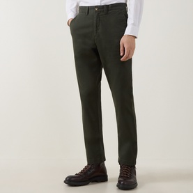 Model wearing Gant Dark Moss Green cotton chino trousers, styled with a white shirt and brown leather lace-up boots.