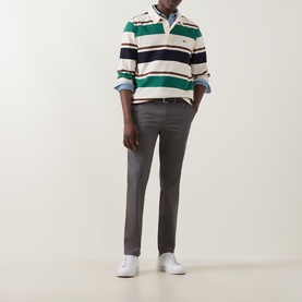 Model wearing Gant Dusky Anthracite slim chino trousers, styled with a striped rugby polo shirt and white trainers.