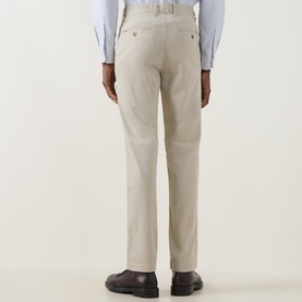 Model wearing Gant clay beige cotton chino trousers, rear view, styled with a light blue shirt and dark loafers.