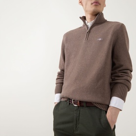 Model wearing Gant Dark Hazelnut Melange half-zip knit, styled with white shirt, brown belt, and dark green trousers.