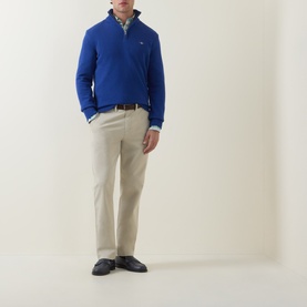 Model wearing Gant Shield Logo Half-Zip Sweater in Crisp Blue, styled with beige chinos, check shirt, and navy loafers.