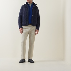 Model wearing Gant Shield Logo Half-Zip Sweater in Crisp Blue, styled with a navy quilted jacket and stone chinos.