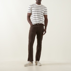 Model wearing Gant Cream Crew Neck T-Shirt with grey stripes, styled with dark brown trousers and white trainers.