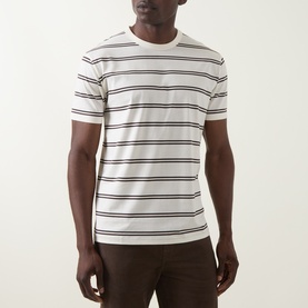 Model wearing Gant Crew Neck T in cream with navy horizontal stripes, styled with dark brown trousers.