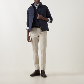Model wearing Gant Evening Blue quilted down gilet over white shirt, styled with stone chinos and dark brown loafers.