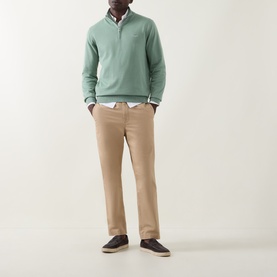 Model wearing Gant Shield Logo Half-Zip Sweatshirt in Surplus Mint with beige chinos, white shirt, and dark trainers.