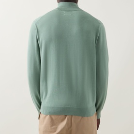 Model wearing Gant Shield Logo Half-Zip Sweatshirt in Surplus Mint, back view, with beige trousers.