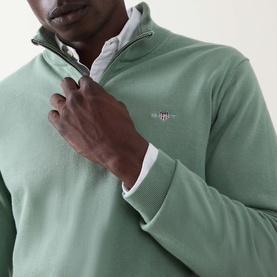 Model wearing Gant Shield Logo Half-Zip Sweatshirt in Surplus Mint, half-zip placket detail, chest logo embroidery, styled over white shirt.