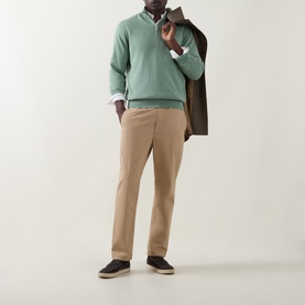 Model wearing Gant Shield Logo Half-Zip Sweatshirt in Surplus Mint, styled with beige chinos, white shirt, and carrying a brown blazer.