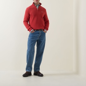 Model wearing Gant Cotton Half Zip in Maple Fire red, styled with blue jeans and a check shirt underneath.