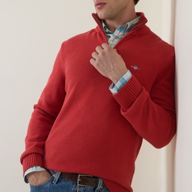 Model wearing Gant Maple Fire cotton half-zip jumper, styled with a blue check shirt and jeans