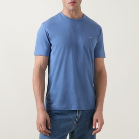 Model wearing Gant Shield Logo T-Shirt in Blue Horizon, crew neck, short sleeves, styled with blue jeans.