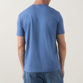 Model wearing Gant Shield Logo T-Shirt in Blue Horizon, rear view, crew neck, short sleeves, styled with light blue jeans.