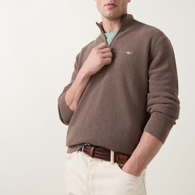 Model wearing Gant Shield Logo Half-Zip Micro Textured Sweatshirt in Dark Hazelnut Melange, styled with mint shirt and cream trousers.