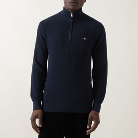Model wearing Gant Shield Half-Zip Textured Sweater in Evening Blue with waffle knit structure, half-zip neckline and embroidered shield logo.