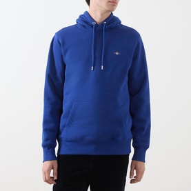 Model wearing Gant Shield Drawstring Hoodie in Crisp Blue with kangaroo pocket, drawstring hood, and small shield logo on chest.
