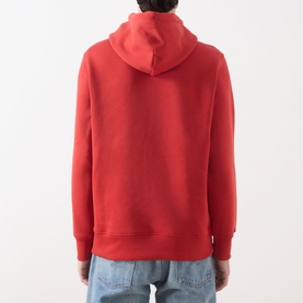 Model wearing Gant Shield Drawstring Hoodie in Maple Fire, back view showing hood with drawstring and ribbed trims, styled with light blue jeans.
