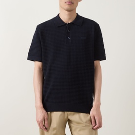 Model wearing Gant Evening Blue cotton textured stripe knit polo shirt, styled with beige chinos