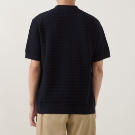 Model wearing Gant Evening Blue cotton knit polo shirt, rear view, styled with beige chinos