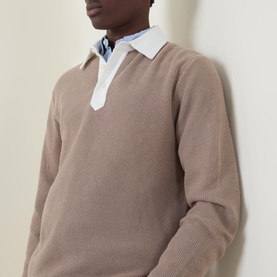 Model wearing Gant Rugby Knitted Polo Shirt in Mist Taupe with contrast white collar, styled over a light blue shirt.