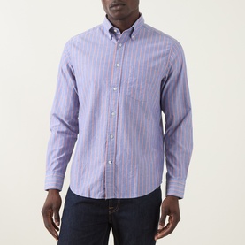 Model wearing Gant Reg Shirt in crisp blue stripe cotton, styled with dark navy jeans. Button-down collar, long sleeves.